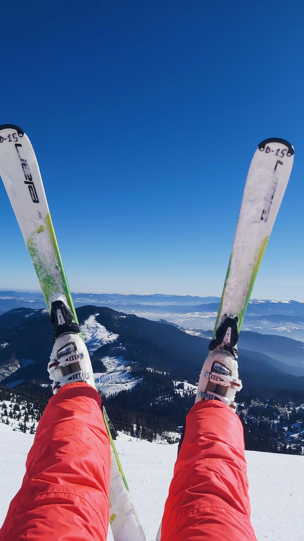 person in red and white snow goggles and red jacket holding blue and white snowboard during