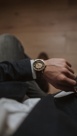 person wearing gold and silver round analog watch