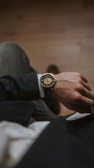 person wearing gold and silver round analog watch