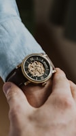 person wearing gold and black chronograph watch