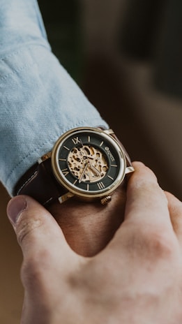 person wearing gold and black chronograph watch