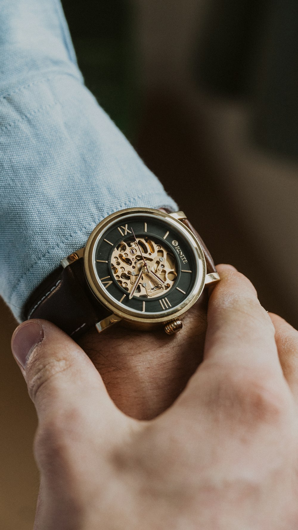 person wearing gold and black chronograph watch