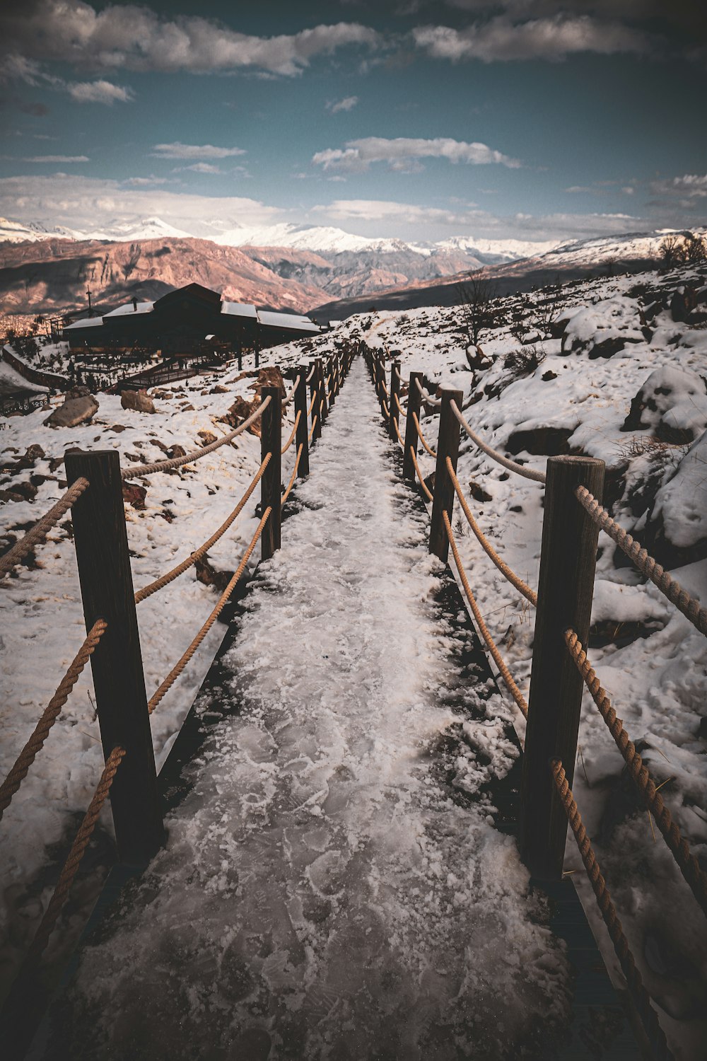 brown wooden fence on snow covered ground during daytime