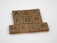Wooden Scrabble tiles spell out the phrase 'ASK FOR HELP' arranged neatly on a white surface. Each tile shows a letter and a number indicating its point value in the game.