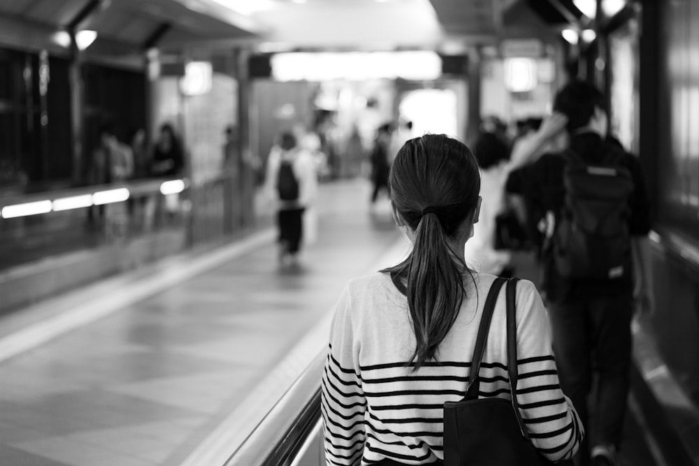 grayscale photo of woman in black and white striped long sleeve shirt