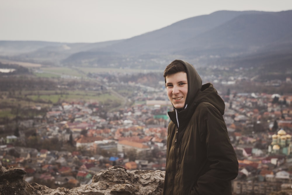 woman in black hoodie standing on top of mountain during daytime