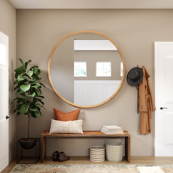 beige entryway with round mirror, bench, plant, and coat hanger
