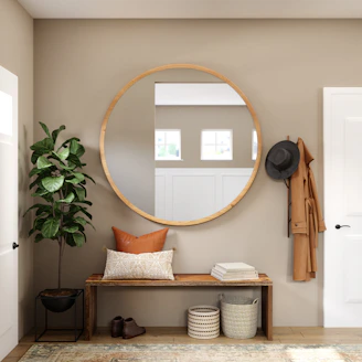 Small entryway organized with a bench, mirror, plant, and wall hooks