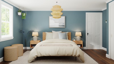 Spacious bedroom with navy blue walls and golden framed artwork, cozy lighting.