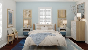 Spacious bedroom featuring soft blue walls and white linens