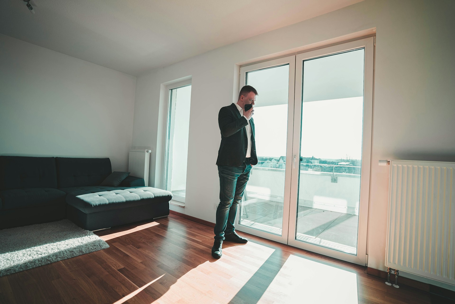 man in black suit standing near glass door