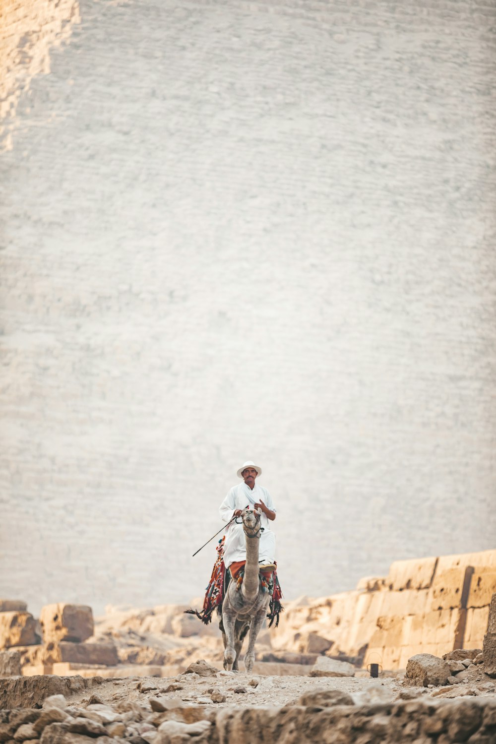 man in white shirt and black pants riding bicycle on brown concrete bridge during daytime