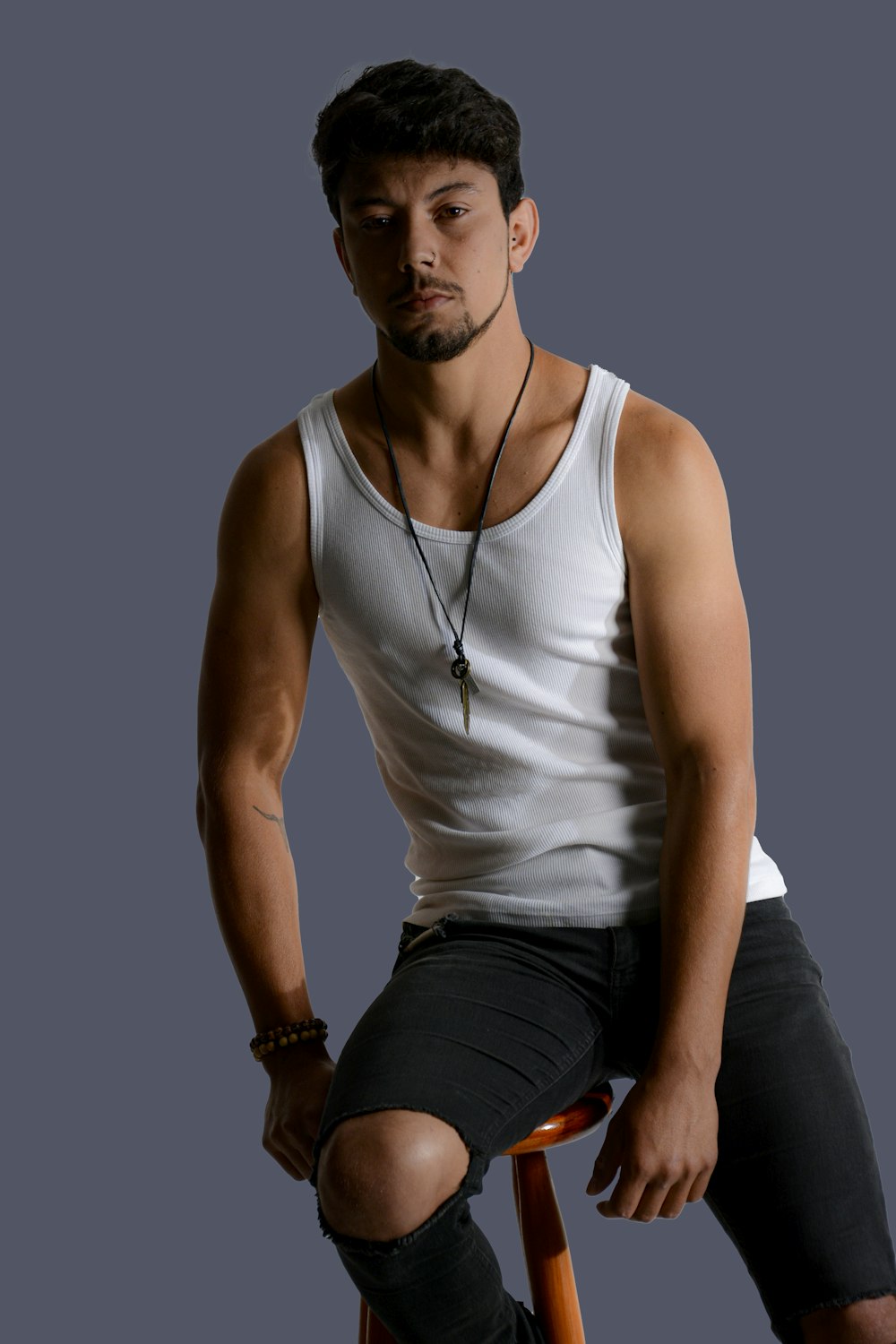 man in white tank top and blue denim jeans