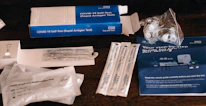 Close-up of a DNA test kit with swabs and instructions on a clean table.