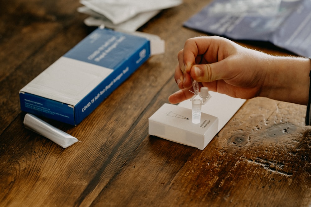 Persona sosteniendo una caja blanca y azul