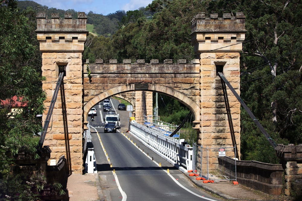 cars on road under bridge during daytime