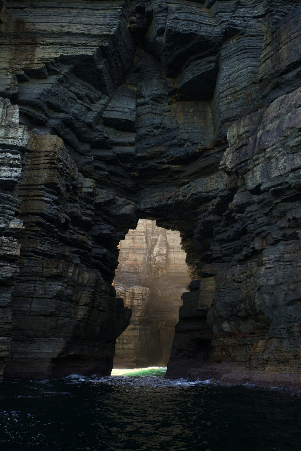 brown rock formation near body of water during daytime