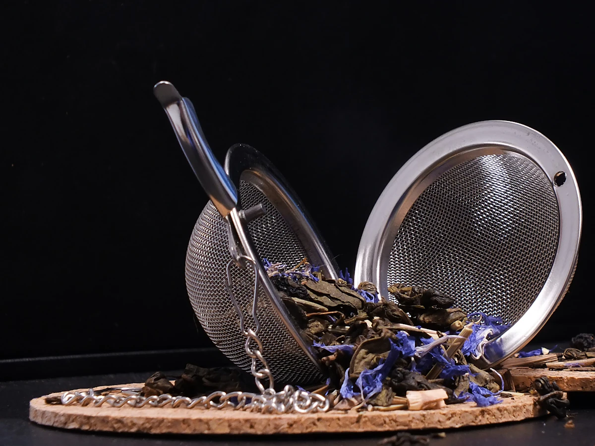 Close-up of a metal tea infuser holding small loose-tea fragments
