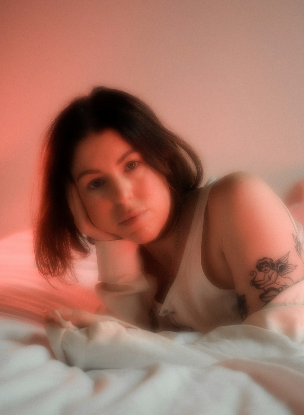 woman in white tank top lying on bed