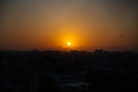 The sun setting over Ghatkopar, casting a golden light on celebratory participants at the marathon finish line.