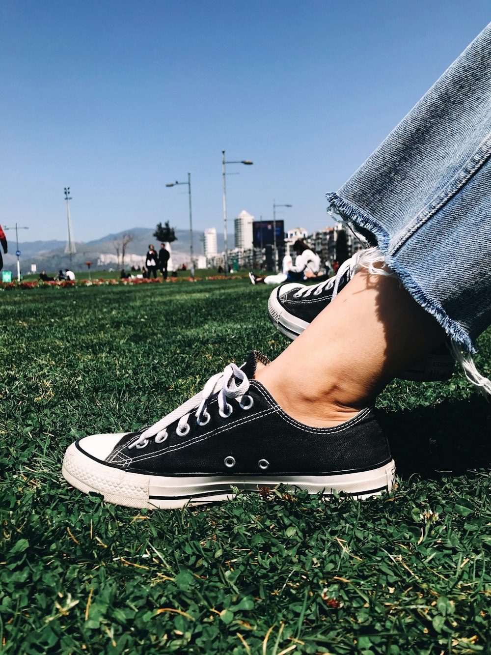 person in black and white converse all star high top sneakers