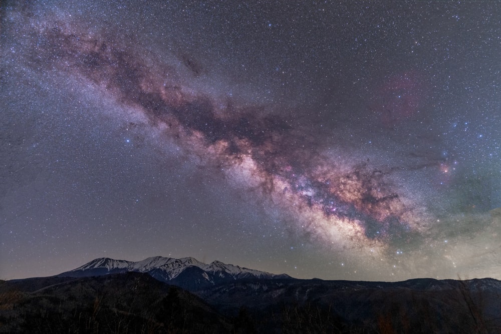 silhouette of mountain under starry night