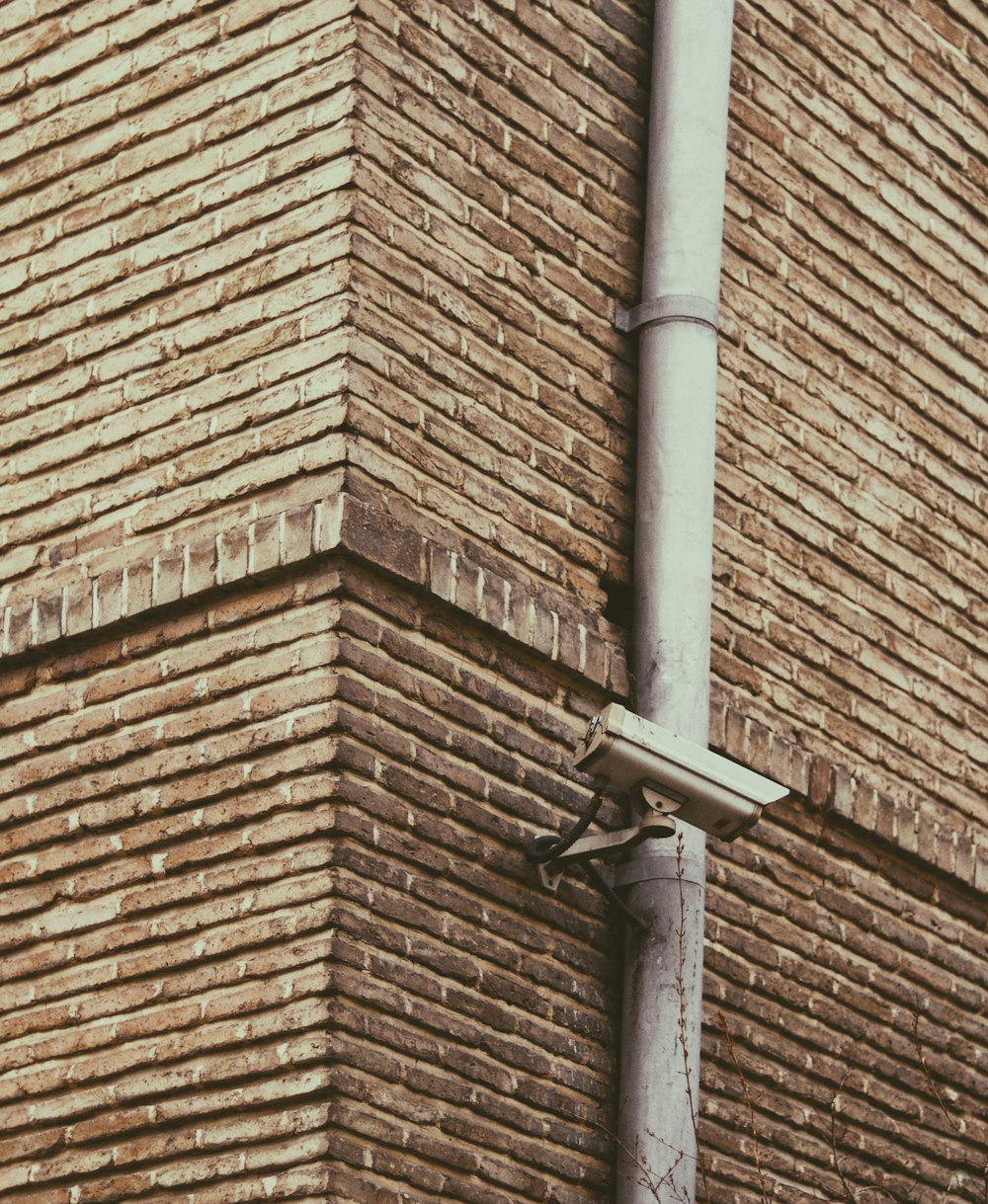 brown brick wall with black metal cross