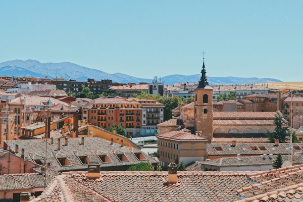Rooftops and a church tower, with the Guadarrama beyond — Segovia, Spain