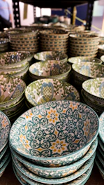 A set of vibrant ceramic bowls stacked neatly, showcasing rich glazes and textures.