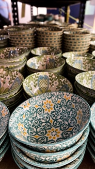A collection of colorful boleiras arranged on a rustic wooden shelf.
