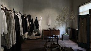 A cozy corner with soft natural light, featuring simple clothing pieces inspired by Korean minimalism