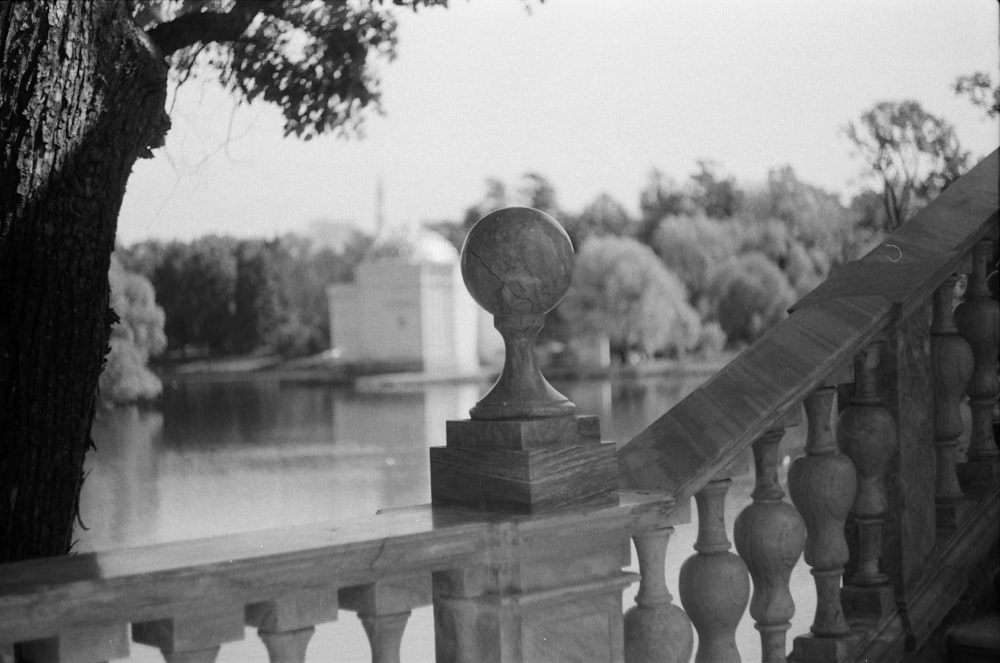 grayscale photo of a man statue near body of water