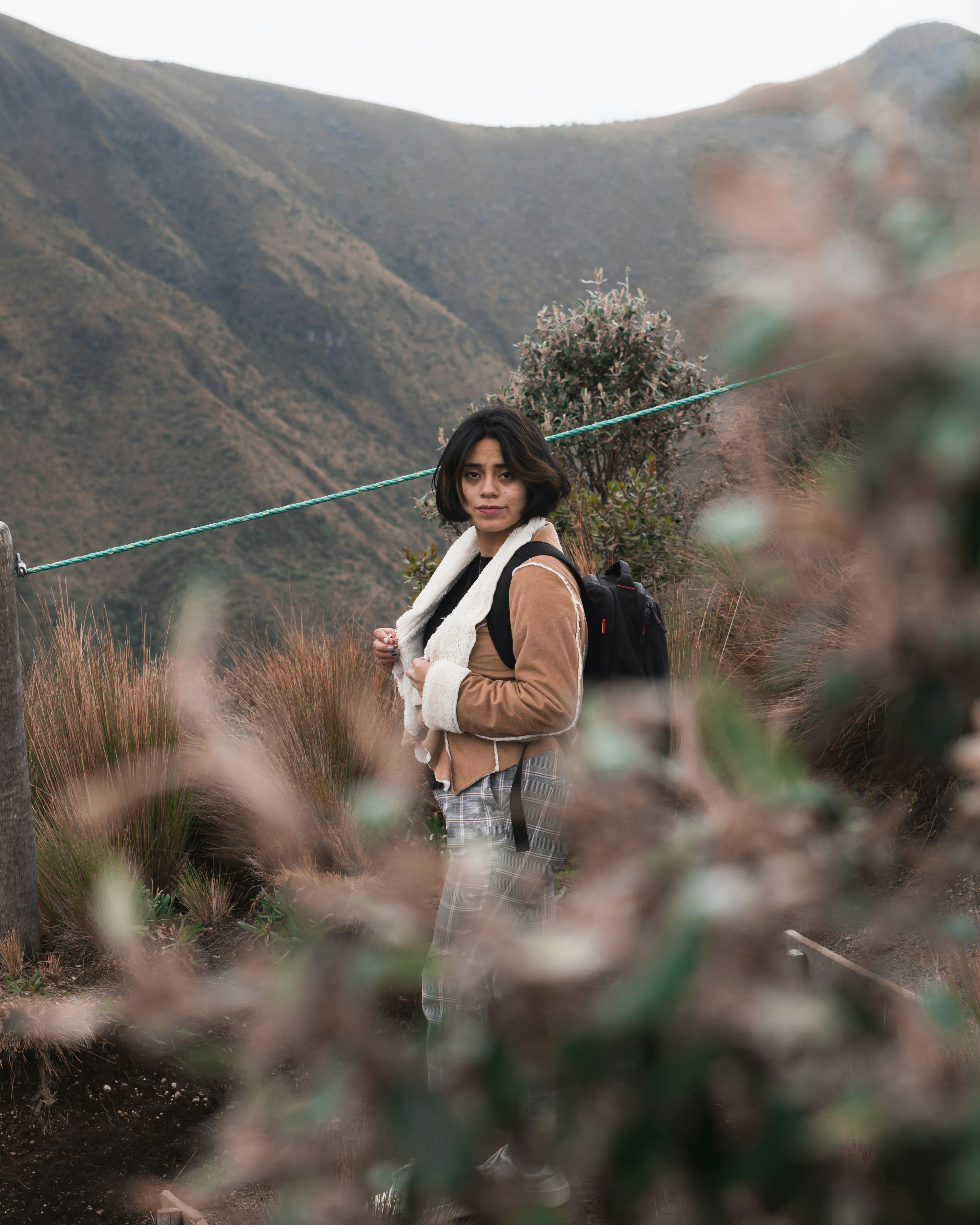 woman in black tank top and white pants standing on green grass field during daytime