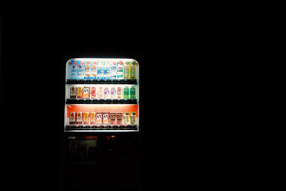 a vending machine is lit up in the dark