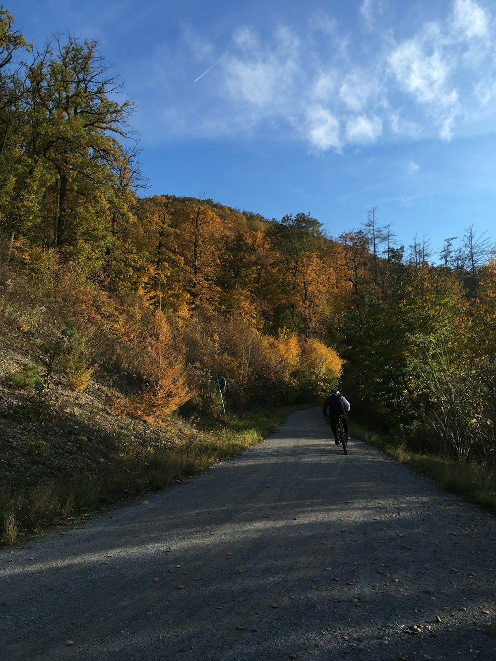 Persona in giacca nera che cammina sulla strada durante il giorno