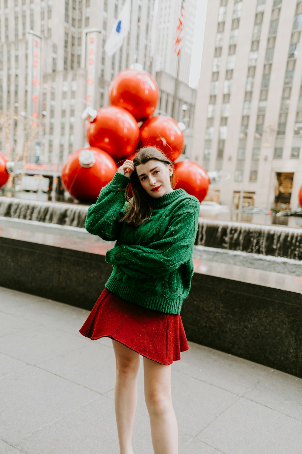 woman in green long sleeve shirt holding red balloons