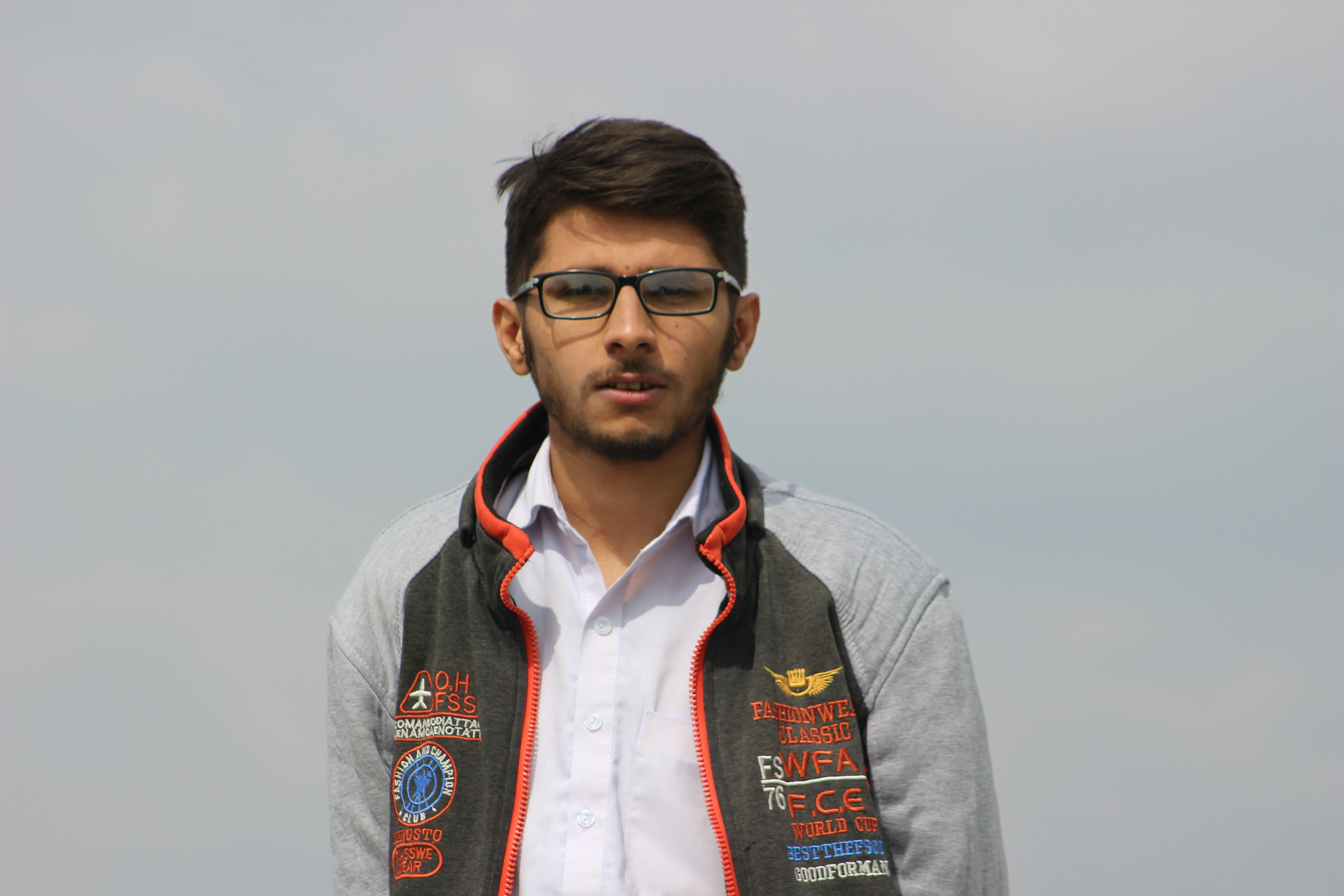 man in gray jacket wearing black framed eyeglasses