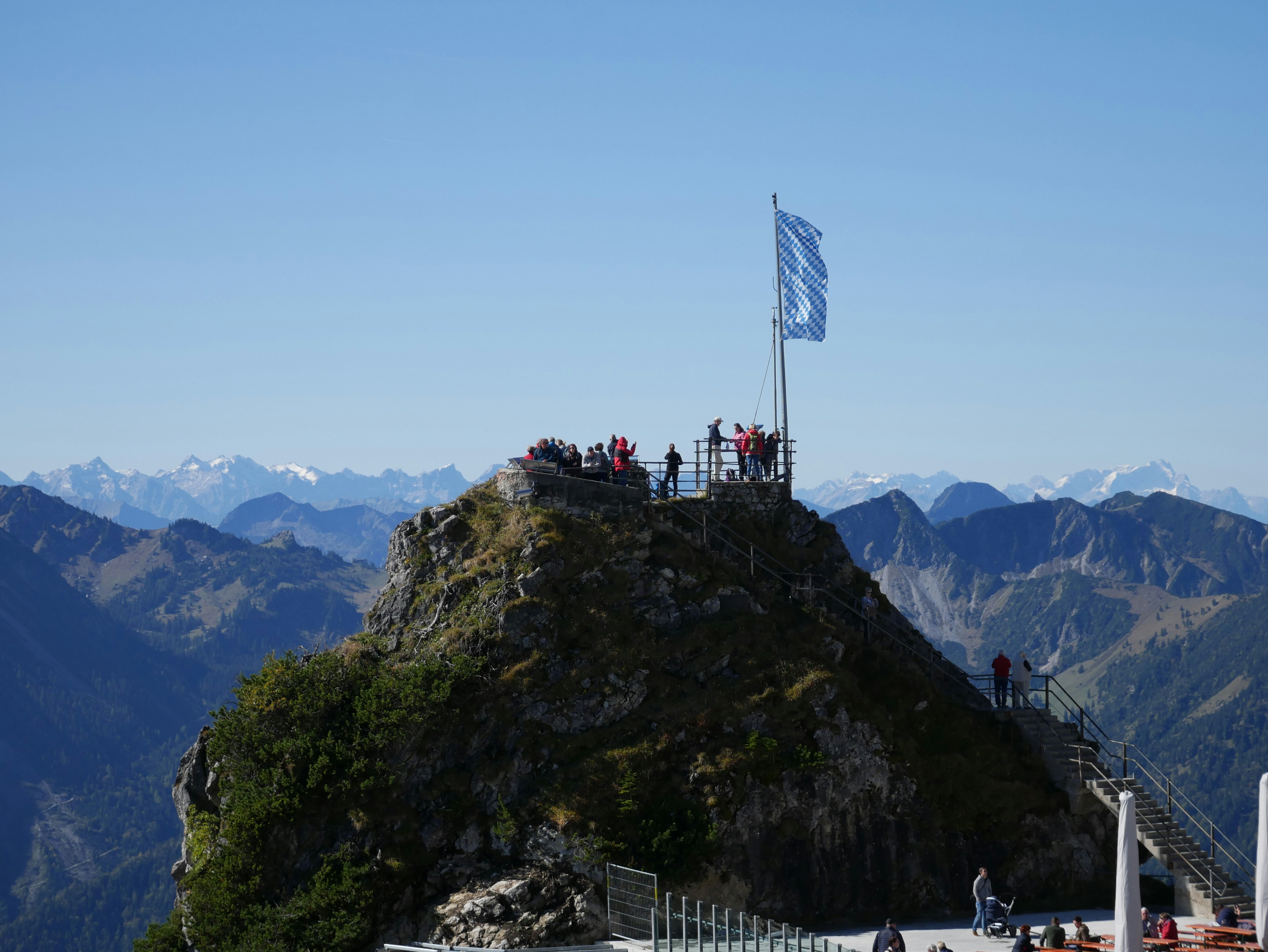 people on top of mountain with us flag during daytime