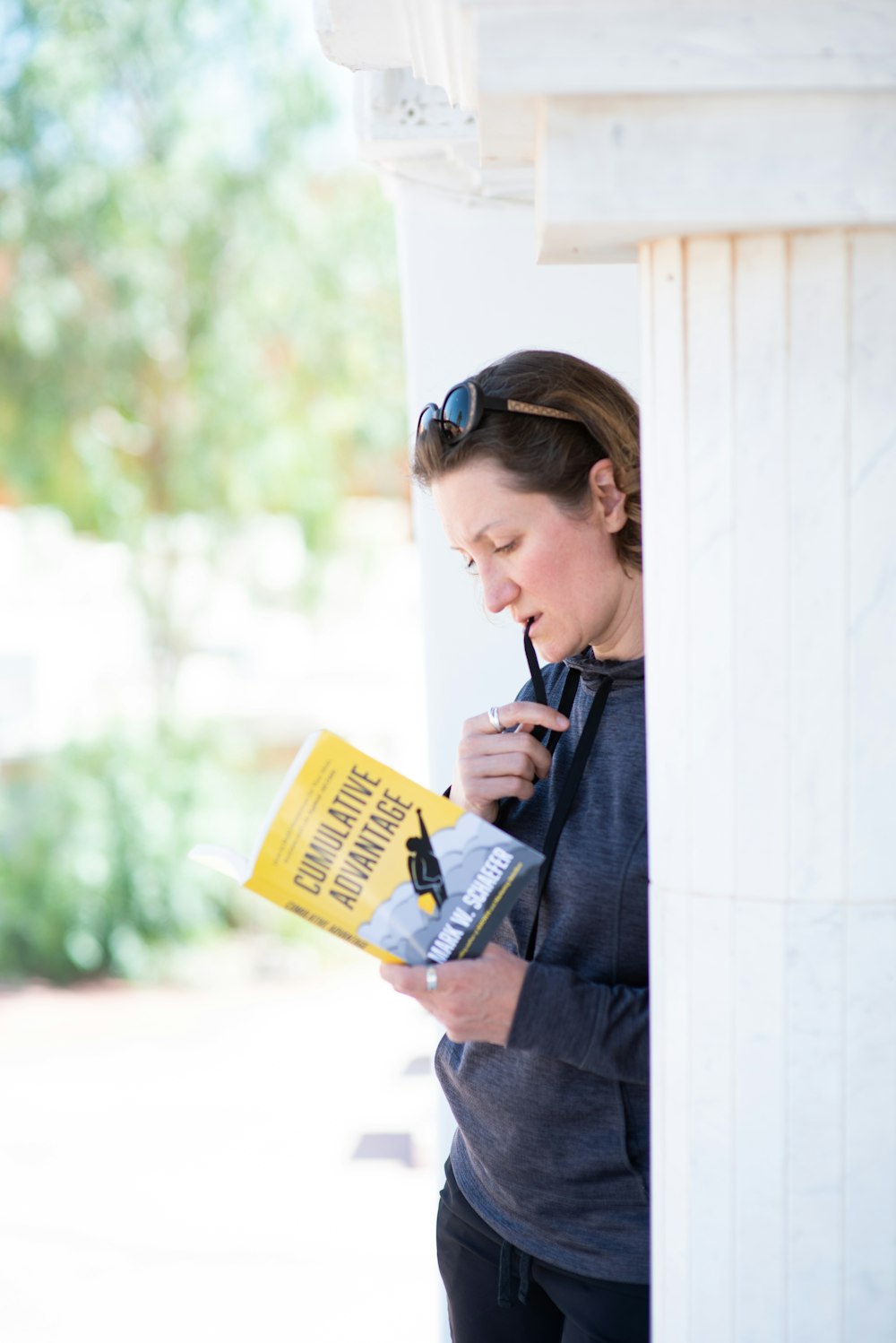 woman in blue long sleeve shirt holding yellow book