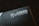 A close-up of a product packaging with the logo 'Glorious PC Gaming Race' printed in white on a dark background. The package features a stylized profile of a bearded face with flowing hair.