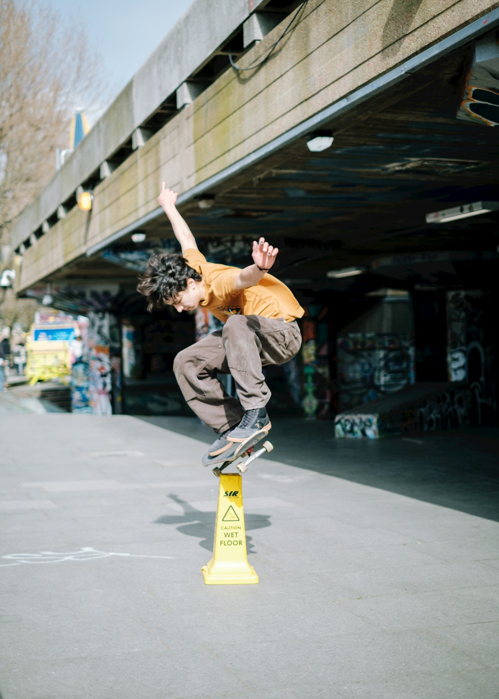 man in gray pants and black shirt doing skateboard stunts