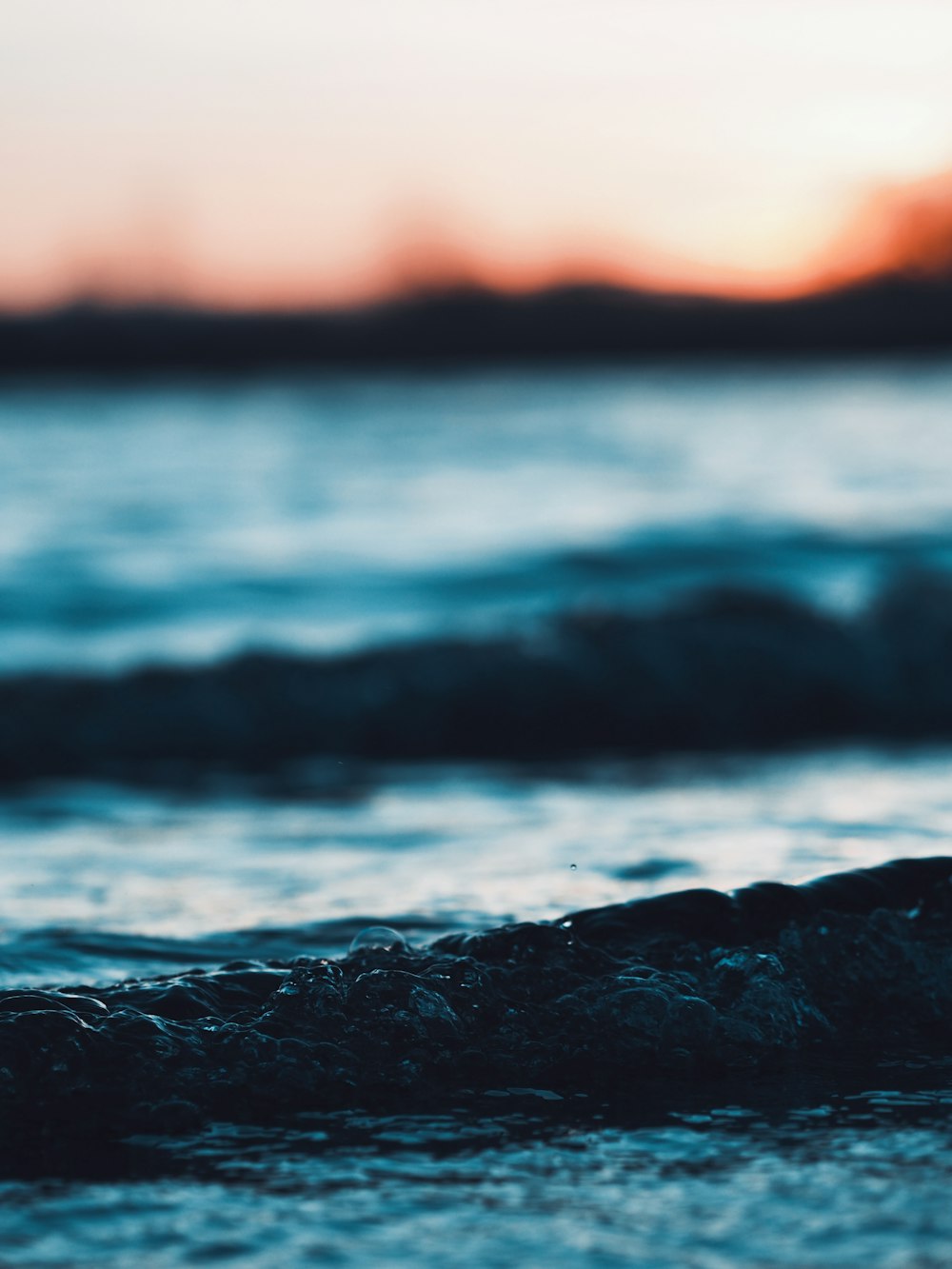 water waves on black rock during daytime