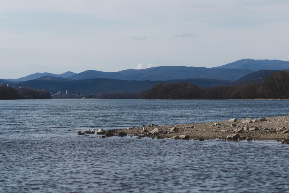 body of water near mountain during daytime