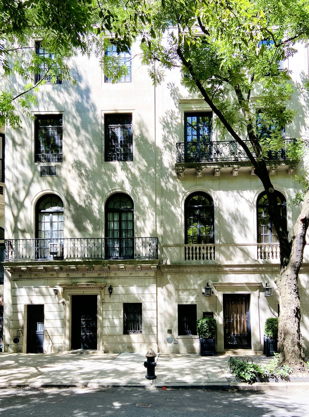 edificio in cemento bianco vicino agli alberi verdi durante il giorno