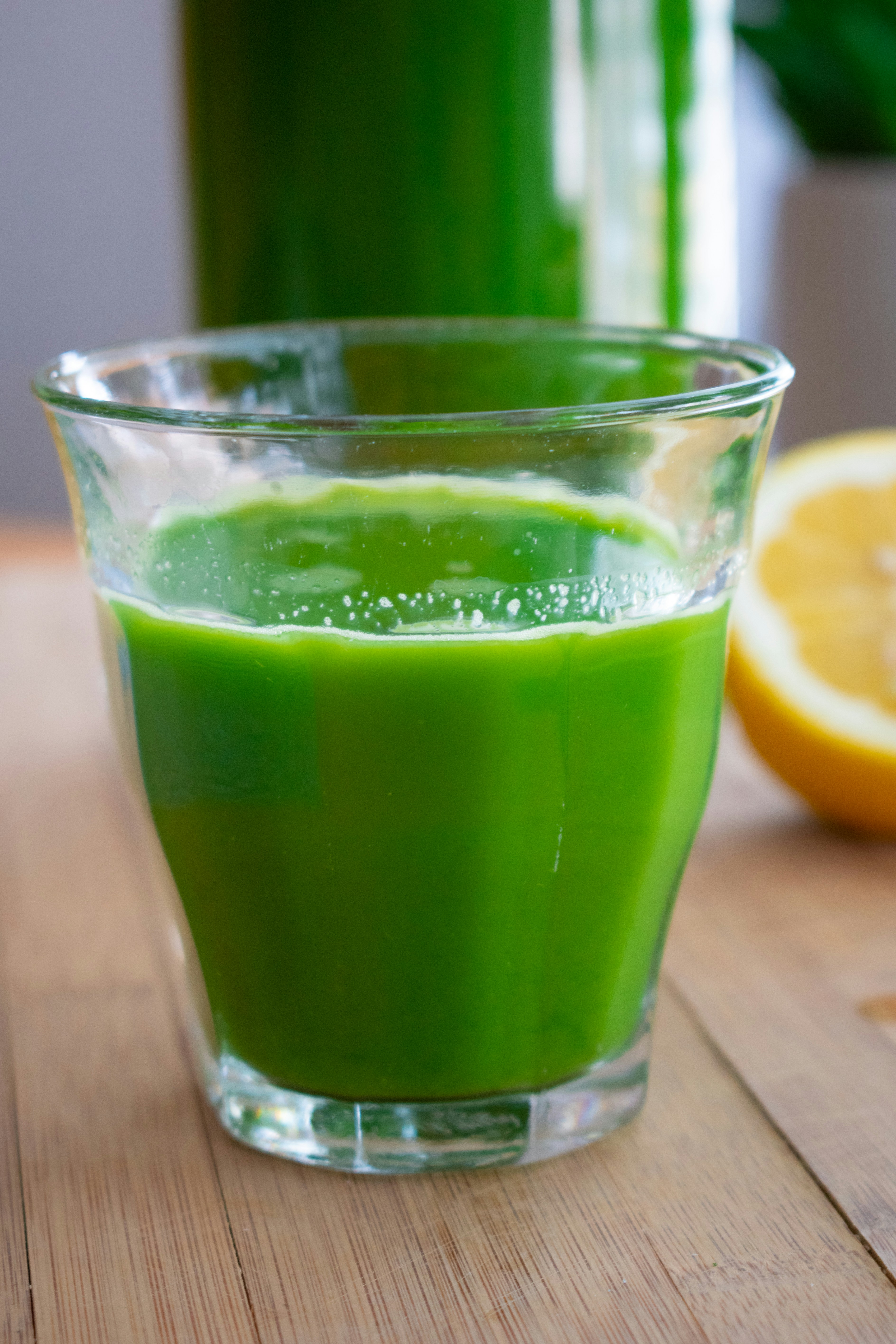 A glass of pale green, refreshing juice with cucumber, celery, and a green apple