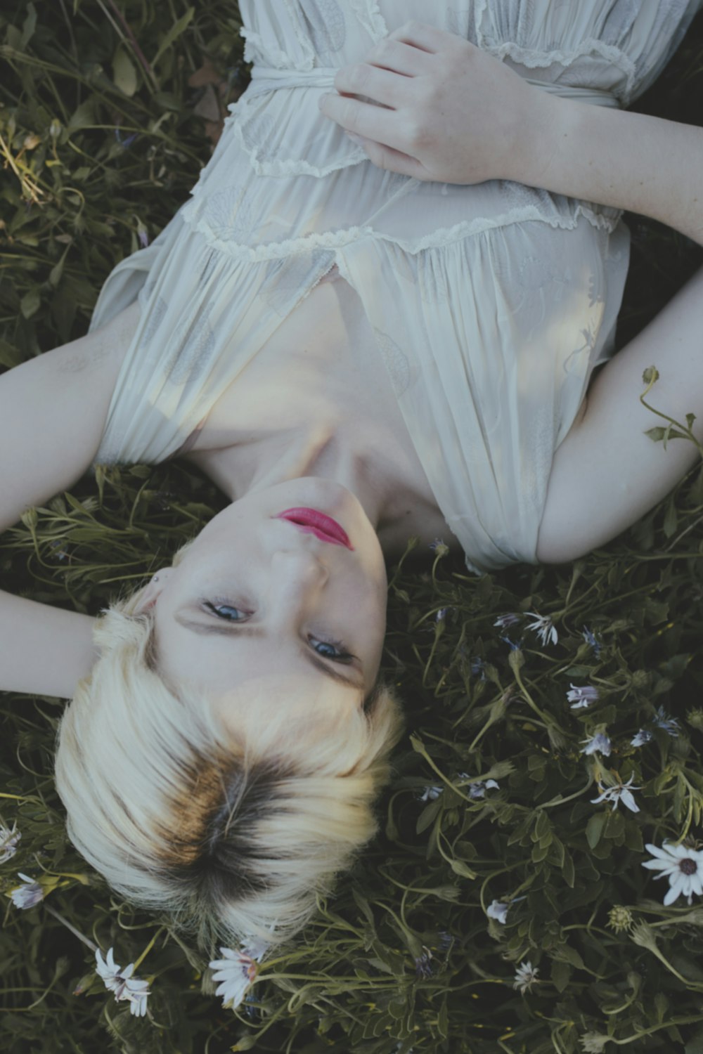 woman in white dress lying on green grass