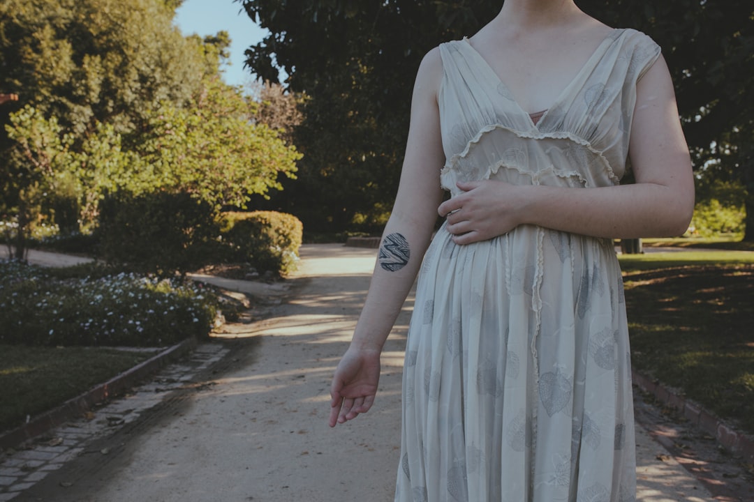 woman in white lace dress standing on gray concrete pavement