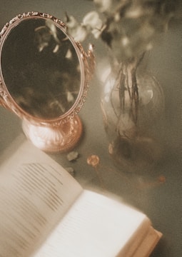 a mirror and a book on a table