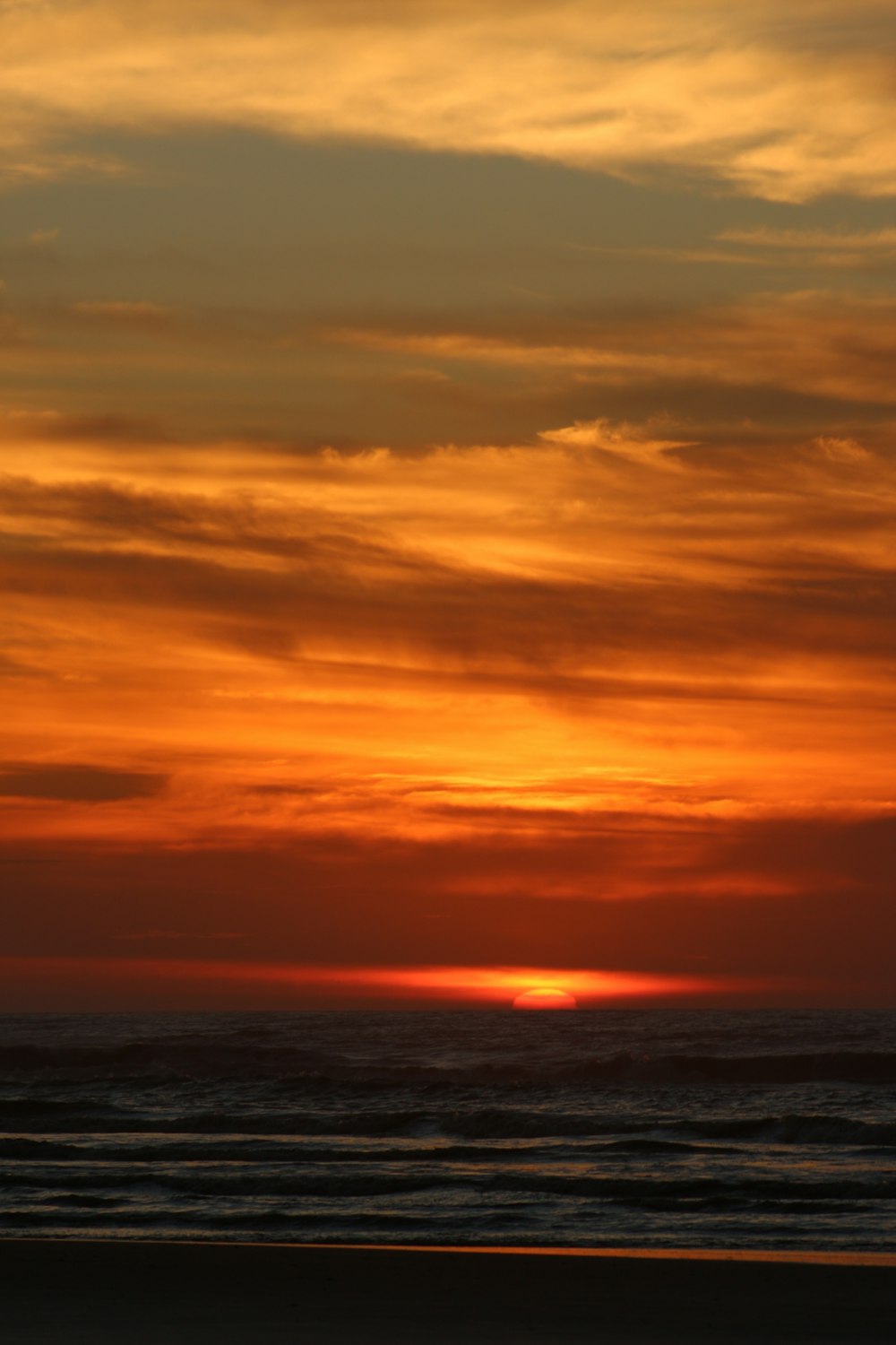 body of water under cloudy sky during sunset