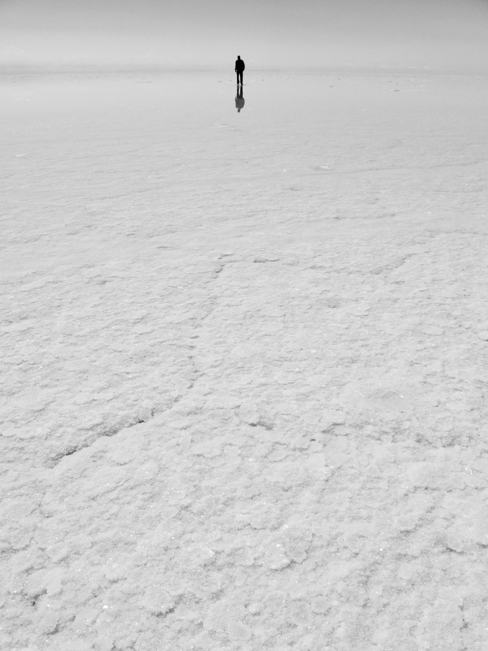 person walking on snow covered field during daytime